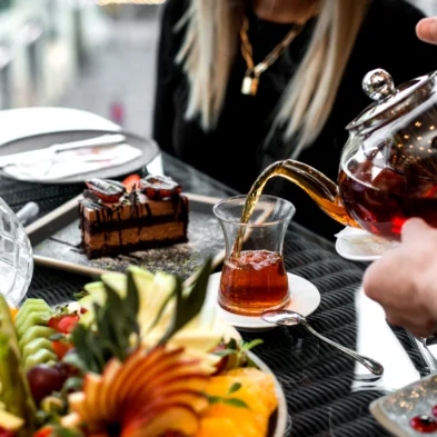 man pours tea into armudu glass